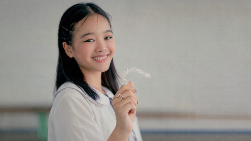teenager holding invisalign braces