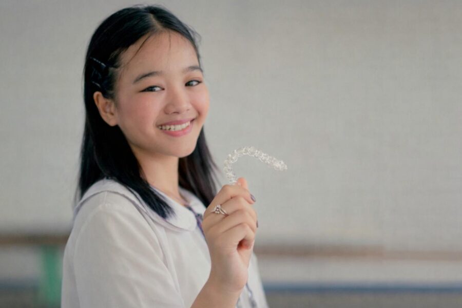 teenager holding invisalign braces